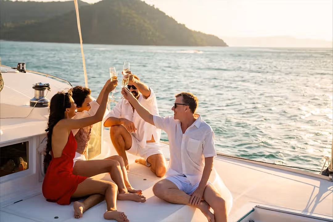 Friends raising glasses on a boat with the Puerto Vallarta skyline behind them.