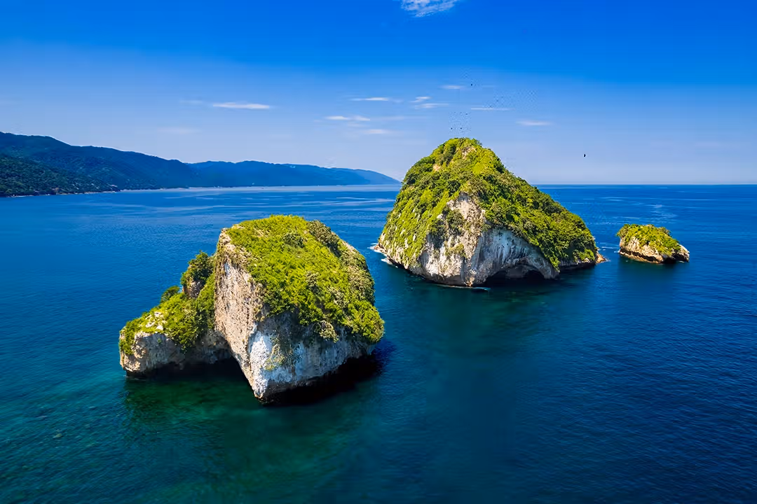 Los Arcos rock formations with a small boat nearby.