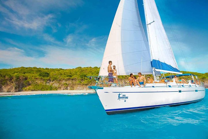Luxury yacht sailing across calm blue waters with Puerto Vallarta’s coastline and Sierra Madre mountains in the background.