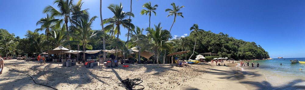 photo of Majahuitas Beach taken from the water with a small boat anchored nearby.